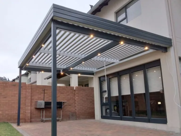 Adjustable aluminium louvre awning installed over a patio with blades open for ventilation