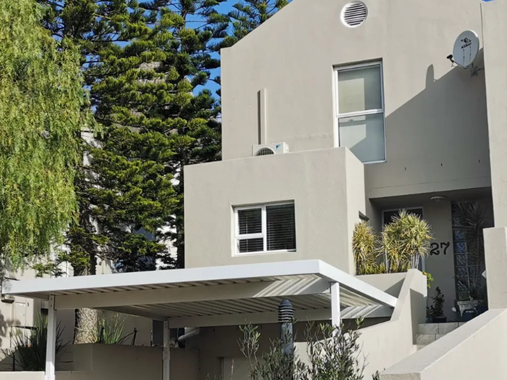 Custom white carport installed beside a modern home