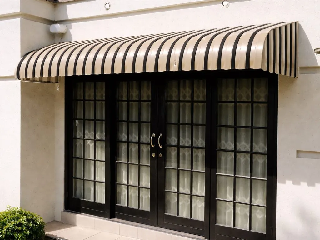 Curved striped aluminium awning installed over patio doors