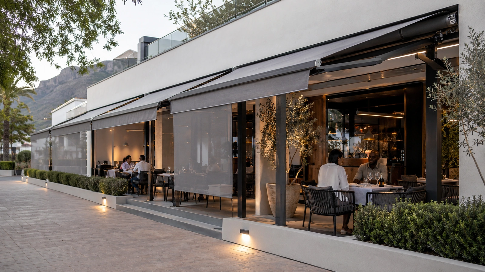 Restaurant terrace covered by a commercial-scale awning above outdoor seating