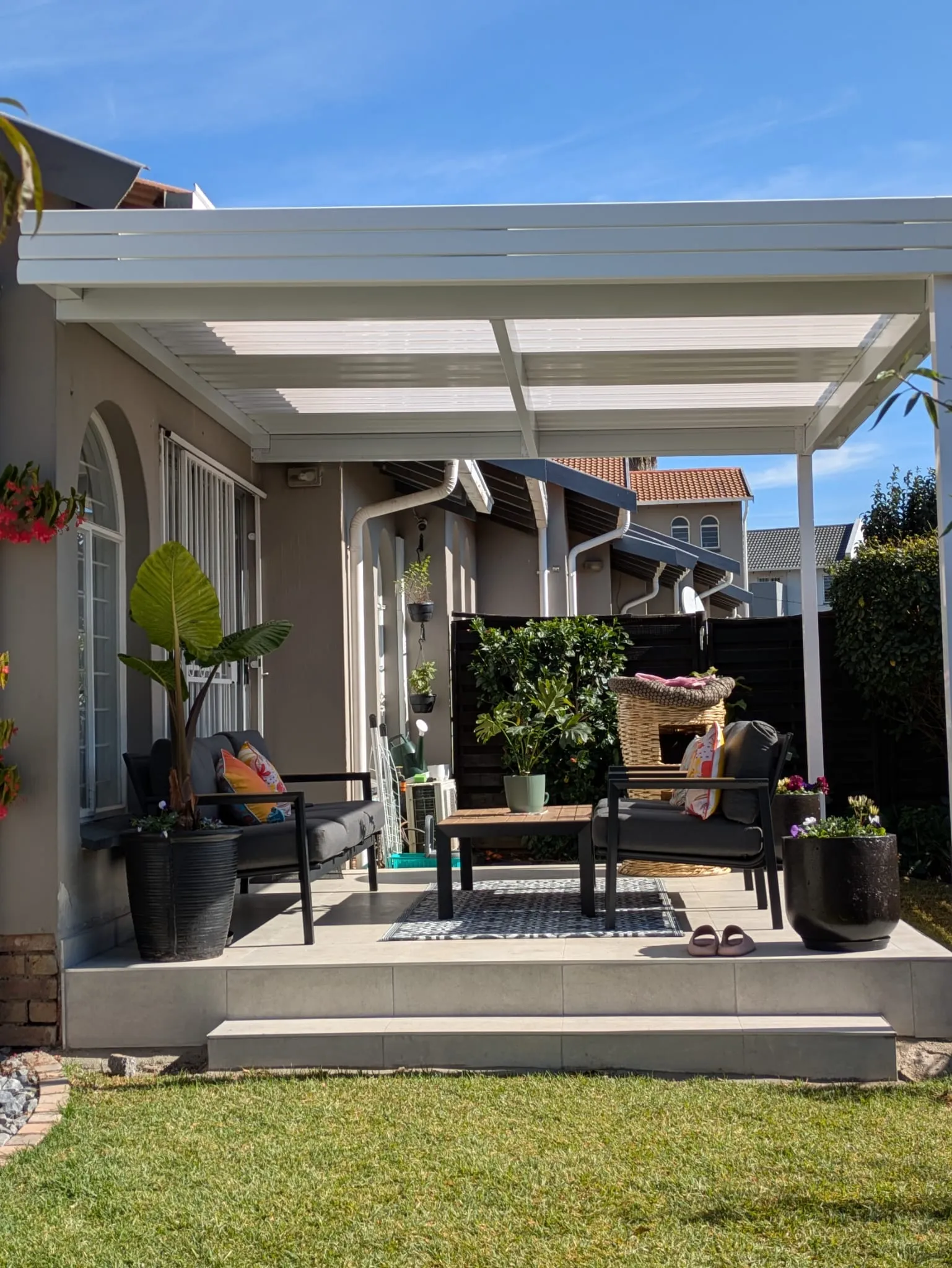 IBR awning with translucent roof panels covering a patio seating area